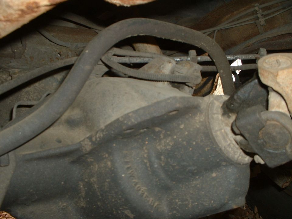 Underside view of a dirty rear differential and suspension components