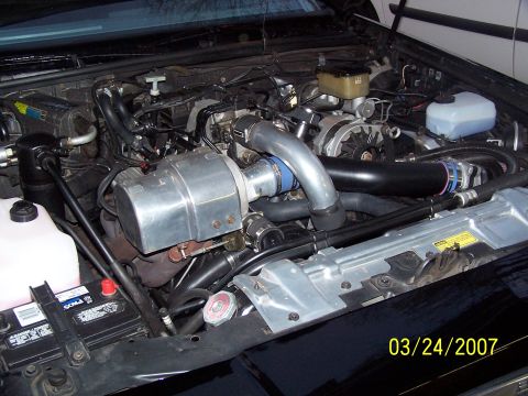 1979 Ford F-150 - The engine bay features a turbocharger setup with custom piping and a visible battery on the left side.