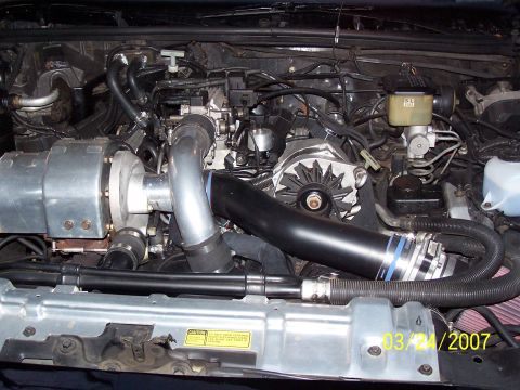 1979 Ford F-150 - Close-up view of a modified engine bay a prominent supercharger and custom intake system, dated March 24, 2007.