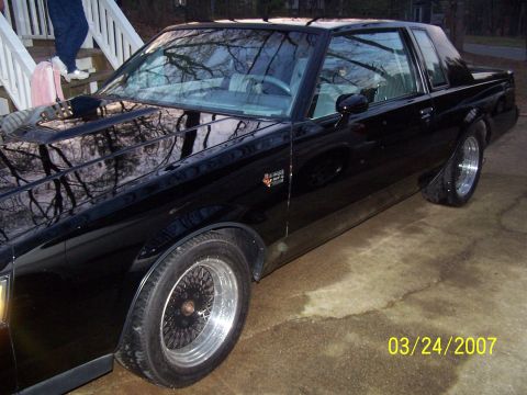 1979 Ford F-150 - A black coupe with wire wheels is parked on a concrete surface.