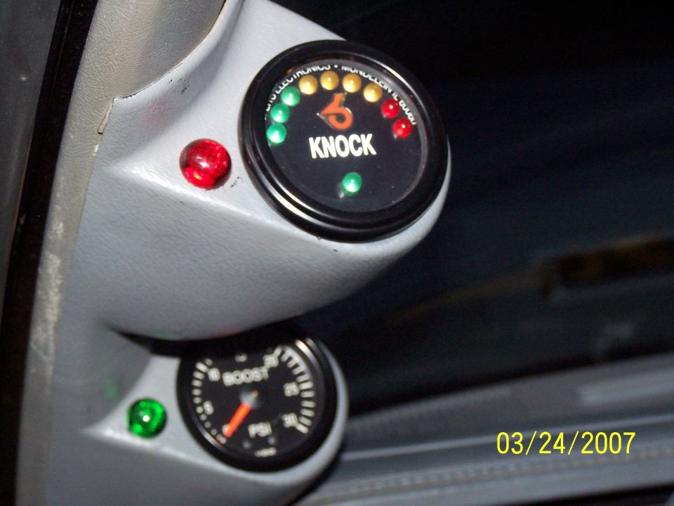 Interior view of a boost gauge and a knock gauge with red and green indicator lights
