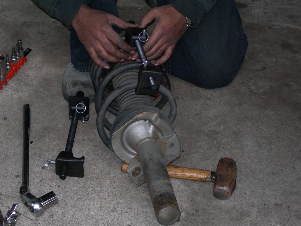 Coilover shock assembly with spring compressor tool attached