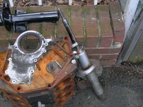 1992 Ford Taurus - Engine block and a suspension part are laid out on the ground near a brick wall.