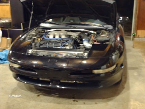 1995 Ford Probe - A black 1995 Ford Probe is parked indoors with its hood open, revealing the engine compartment.