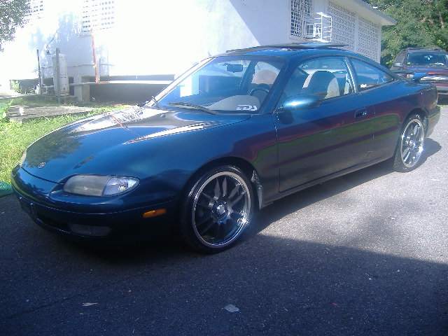 Dark teal Mazda MX-6 coupe, front three-quarter, with black aftermarket wheels