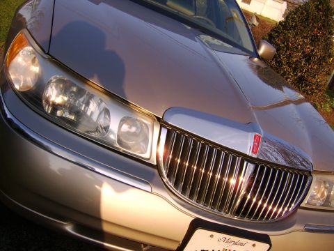 1996 Mercury Grand Marquis - Close-up of a 2003 Lincoln Town Car's front end, its distinctive grille and headlights.