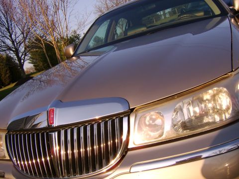 1996 Mercury Grand Marquis - The front grille and headlights of a tan Lincoln Town Car are visible in this close-up shot.