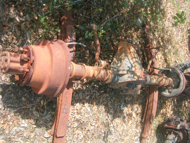 rusty rear axle with leaf springs and brake drums