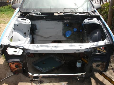 1992 Ford Taurus - The engine bay of a car is shown disassembled, with various parts removed and some areas taped off.