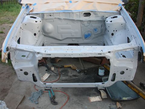 1992 Ford Taurus - Engine bay of a car undergoing restoration, showing bare metal and preparation for new paint.