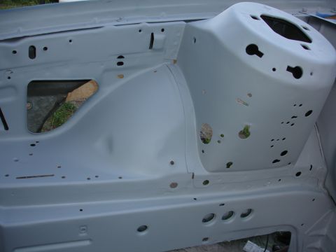 1992 Ford Taurus - The bare metal of a car's engine compartment shows various holes and mounting points.