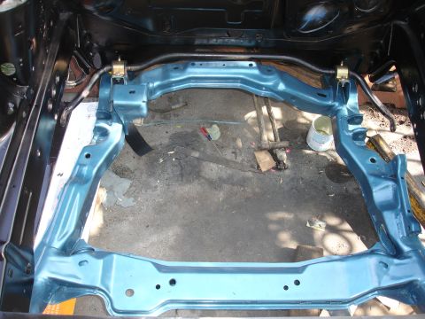 1992 Ford Taurus - Car subframe assembly with sway bar, likely undergoing restoration or repair.