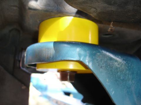 1992 Ford Taurus - Close-up view of a yellow suspension bushing installed on a vehicle's suspension component.