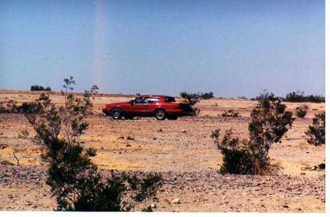 1993 Ford Bronco - Red coupe in desert landscape. Album claims 1993 Ford Bronco, but this is incorrect.
