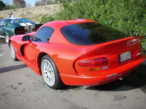 1998 Ford Crown Victoria - Rear three-quarter view of a red Dodge Viper GTS coupe with split-spoke wheels, parked beside a green Shelby Mustang fastback.