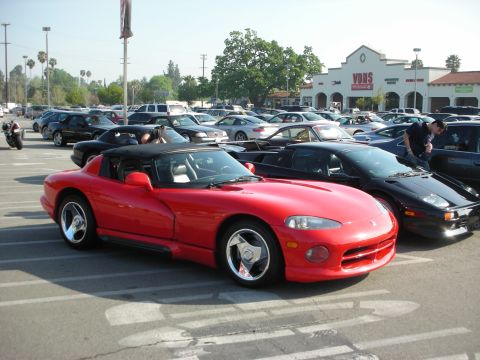 1998 Ford Crown Victoria - red first-generation Dodge Viper roadster parked among other cars in a lot in front of a Vons supermarket.