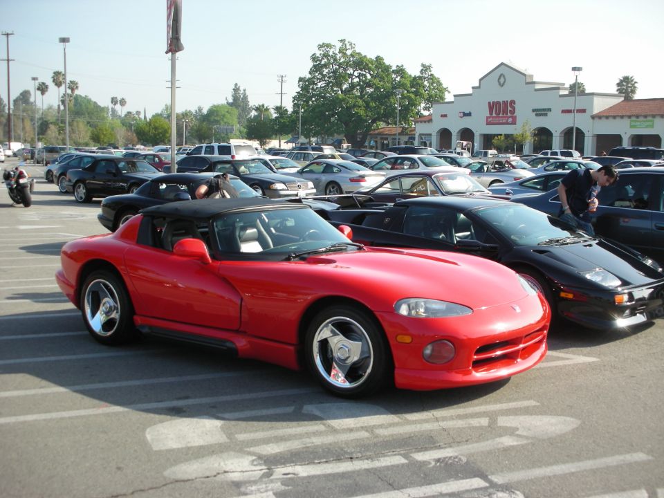 Red Dodge Viper roadster parked in a lot in front of a Vons supermarket