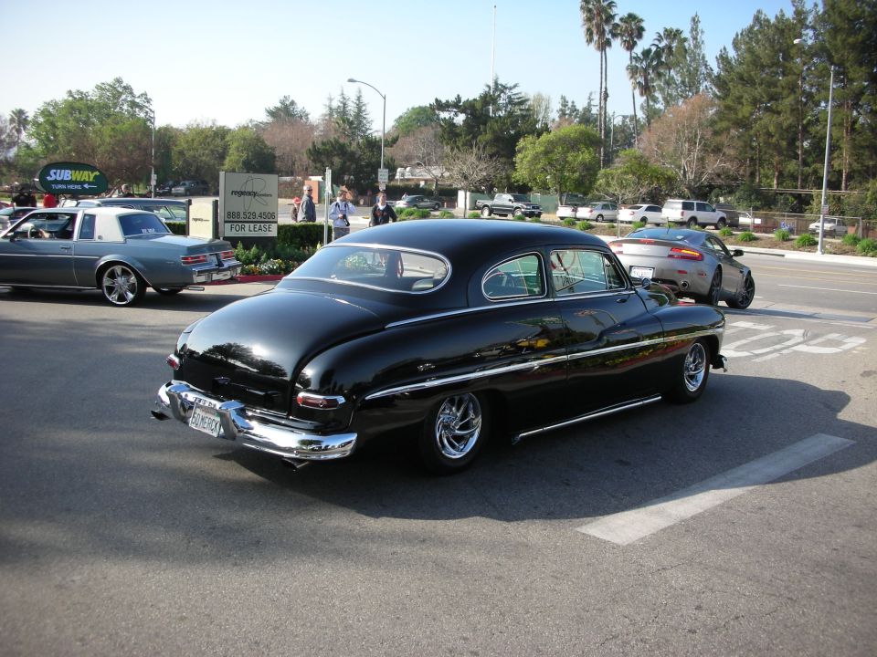 Black chopped 1949-1951 Mercury custom sedan driving on a street