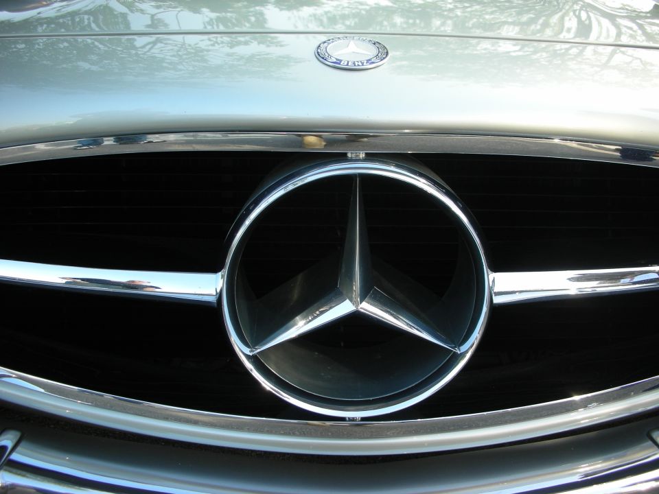 Close-up of a chrome Mercedes-Benz three-pointed star grille emblem
