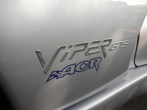 1998 Ford Crown Victoria - Close-up of a silver car body panel displaying chrome 'VIPER GTS' lettering above a blue 'ACR' decal with a checkered-flag graphic.