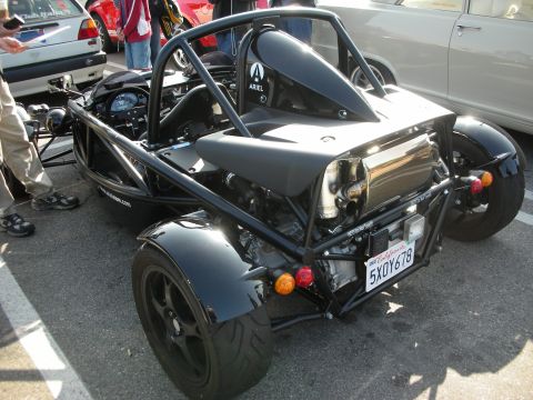 1998 Ford Crown Victoria - black skeletal tube-frame Ariel-badged track car shown rear three-quarter with exposed exhaust and a California plate at a meet.