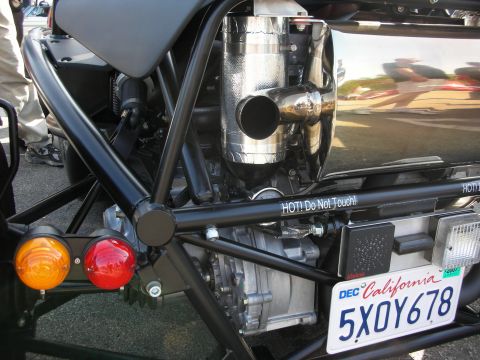 1998 Ford Crown Victoria - Close-up of a tube-frame car's rear showing a heat-shielded exhaust, amber and red lights, and a California plate '5XOY678'.