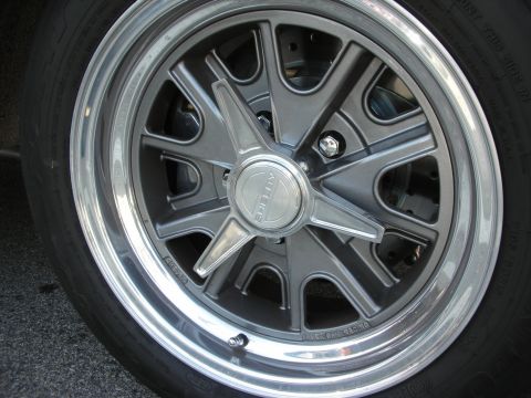 1998 Ford Crown Victoria - Close-up of a gray five-spoke alloy wheel with a polished outer lip and center cap mounted on a low-profile tire.