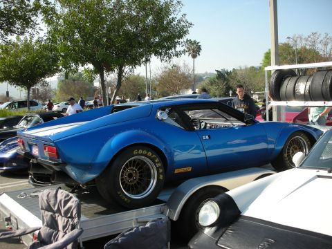 1998 Ford Crown Victoria - blue mid-engine De Tomaso Pantera fitted with Goodyear racing slicks sits loaded on an open trailer.