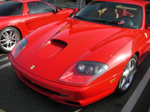 1998 Ford Crown Victoria - Close front-quarter view of a red Ferrari 550 Maranello showing its hood vent, prancing-horse badge and five-spoke wheel.