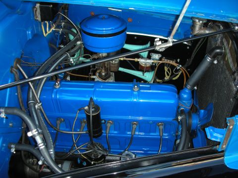 1998 Ford Crown Victoria - detailed engine bay of a vintage vehicle finished in bright blue, with an inline engine and round air cleaner.