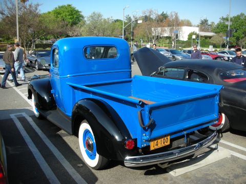 1998 Ford Crown Victoria - blue-and-black vintage pickup with whitewall tires shows its bed and tailgate, plate reading L4-100, at a car meet.