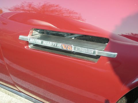 1998 Ford Crown Victoria - Close-up of a chrome side badge reading Aston Martin V8 DBS on glossy red bodywork.