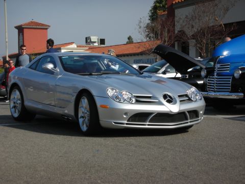 1998 Ford Crown Victoria - Front three-quarter view of a silver Mercedes-Benz SLR McLaren parked near storefronts with people in the background.