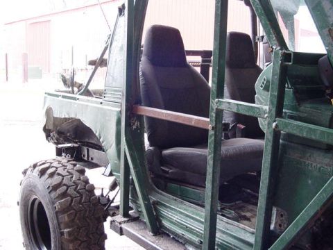 1992 Ford Bronco - The interior of a modified off-road vehicle shows bucket seats and a custom roll cage structure.