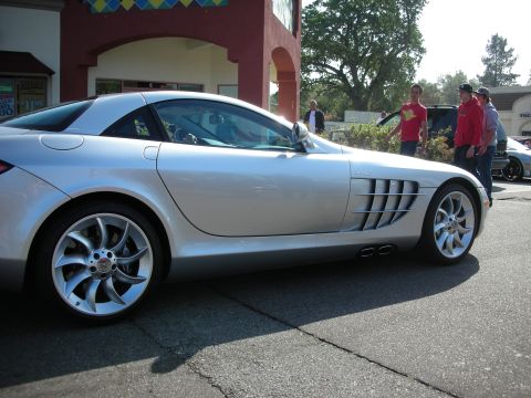 1998 Ford Crown Victoria - Side profile of a silver Mercedes-Benz SLR McLaren highlighting its side exhaust vents and turbine-style wheels.