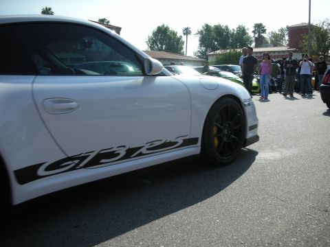 1998 Ford Crown Victoria - white Porsche 911 GT3 RS is shown in profile with its GT3 RS side decal, black wheels and yellow brake calipers.