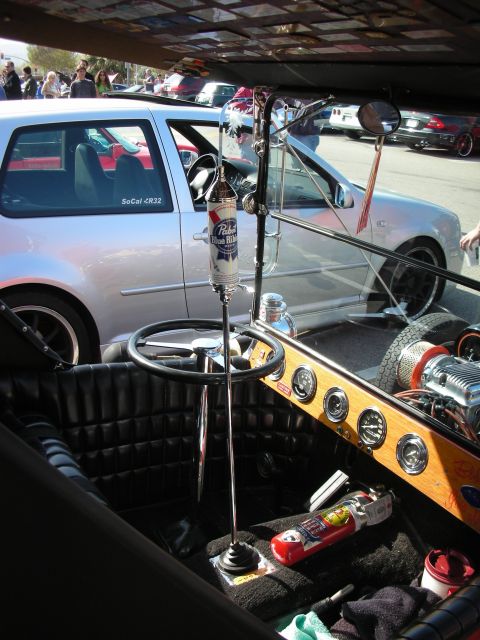 1998 Ford Crown Victoria - Open hot rod interior with tufted black seats, a wood dash with gauges and a Pabst Blue Ribbon can on the tall shifter.