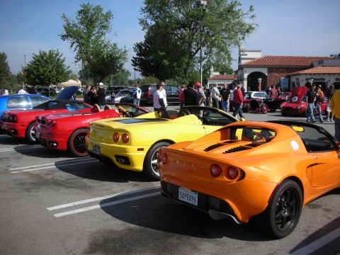 1998 Ford Crown Victoria - row of parked exotics including a yellow Ferrari 360 Spider and an orange Lotus Elise at a car meet.
