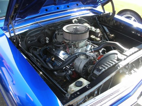 1998 Ford Crown Victoria - polished chrome small-block V8 with chrome air cleaner mounted in the engine bay of a blue car.