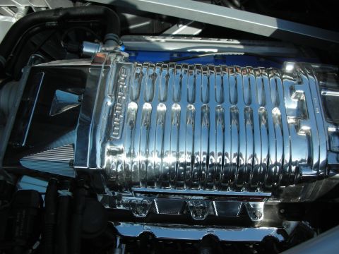 1998 Ford Crown Victoria - Close-up of a polished Whipple twin-screw supercharger mounted on a blue engine.