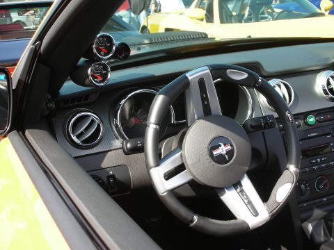 1998 Ford Crown Victoria - Interior of a Ford Mustang showing the pony-badged steering wheel, gauge cluster and extra dash pods.