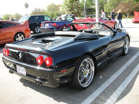 1998 Ford Crown Victoria - Rear three-quarter of a black Ferrari 355 F1 Spider convertible with chrome wheels at an outdoor car meet.