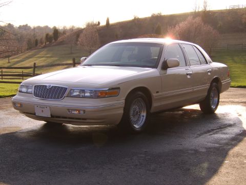 1996 Mercury Grand Marquis - A tan 1996 Mercury Grand Marquis sedan is parked outside on a sunny day.