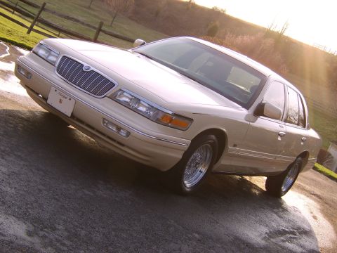 1996 Mercury Grand Marquis - A cream-colored 1996 Mercury Grand Marquis is shown from a three-quarter front angle on a paved surface.