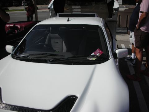 1998 Ford Crown Victoria - Close view of a white modified sports car's hood and windshield with a vented bumper and raised doors.