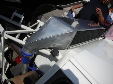 1998 Ford Crown Victoria - race car engine bay showing a cast exhaust manifold, blue silicone piping and a cone air filter.
