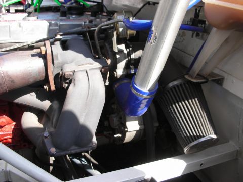 1998 Ford Crown Victoria - Detail of a race car engine bay with a turbo intake manifold, blue silicone hose and a cone air filter.