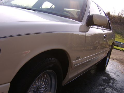 1996 Mercury Grand Marquis - Side profile of a 1996 Mercury Grand Marquis, highlighting its body lines and chrome trim.