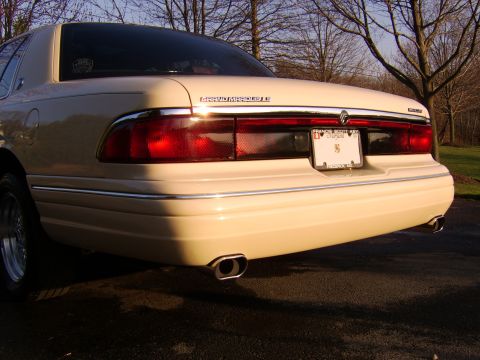 1996 Mercury Grand Marquis - The rear of a cream-colored Mercury Grand Marquis LS is shown, with chrome accents and dual exhaust tips.
