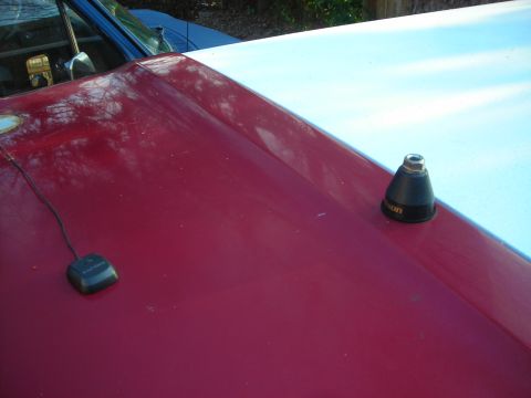1995 Ford Bronco - A close-up view of a vehicle's hood shows an antenna and a GPS receiver, with another vehicle in the background.